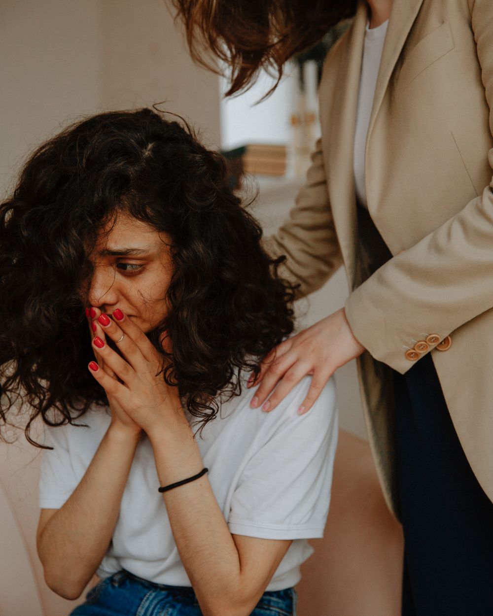 A therapist resting a hand on a client’s shoulder during a session
