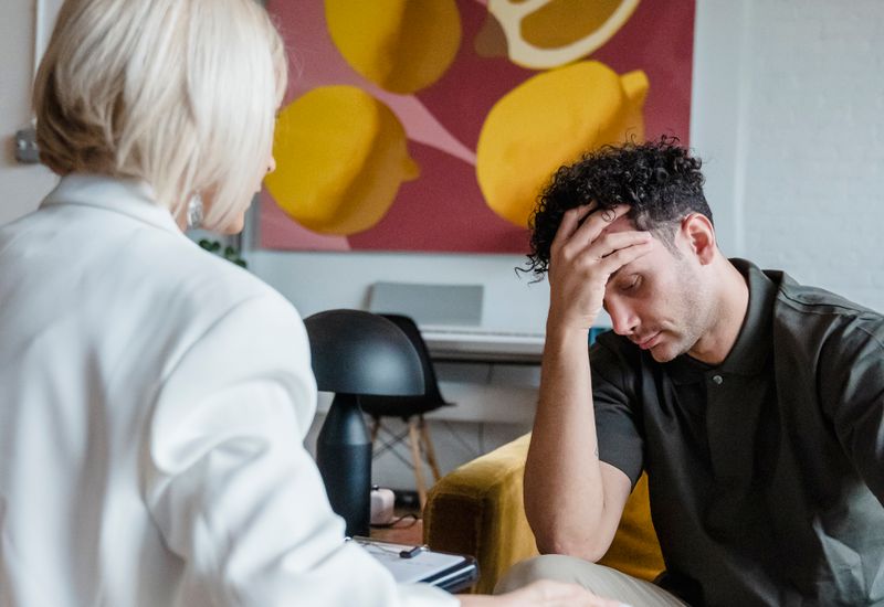 A young man talking with a therapist in a bright consulting room