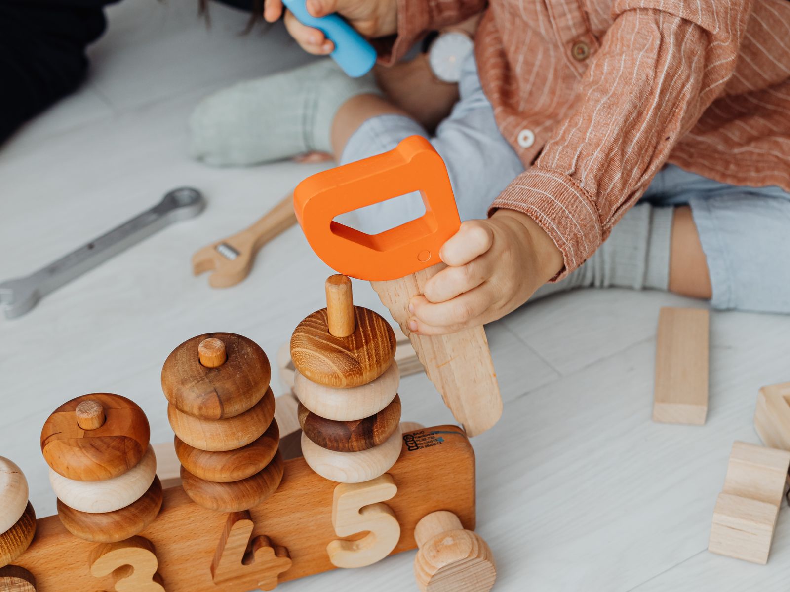 A child playing with wooden toys on the floor