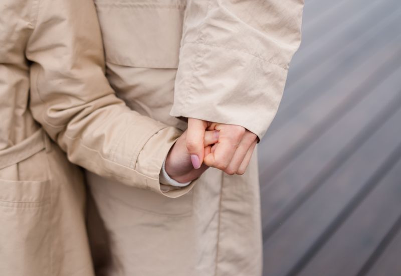 A parent and child holding hands